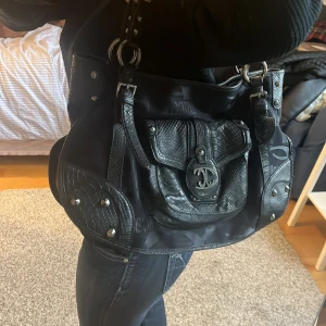 Svart axelväska  - Svart axelväska med nitar i toppenskick! Mycket utrymme och många innerfickor. ❣️