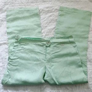 Linnebyxor  - Mintgröna linnebyxor från Mango (MNG), använda fåtal gånger och i mycket bra skick. Storlek 38. Midjemått ca 80 cm, grenhöjd 22 cm, Innerbenslängd 69 cm. Använd gärna KÖP NU om du vill köpa.