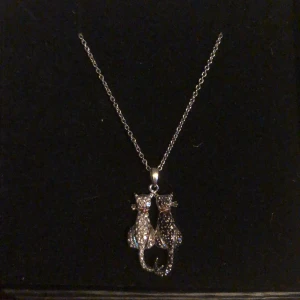 Halsband med katter - Ett super gulligt halsband med två katter på. Katterna skimrar av alla diamanter. Vet tyvärr inte materialet därav det billiga priset. 