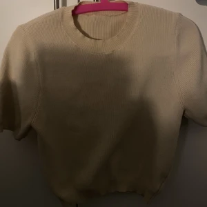 Stickad tröja  - Krämvit stickad kortärmad tröja. Super fin och har inga defekter då den bara är använd runt 3 gånger