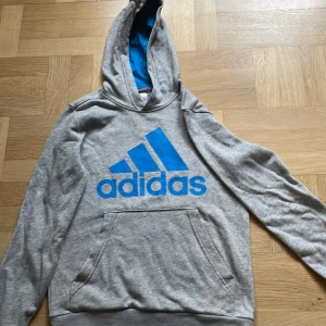 Grå adidas hoodie. Stl 152 - Grå adidas hoodie i väldigt bra skick. Avtänd ett par gånger. Den är aningen liten i storleken.