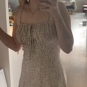 Somrig Klänning - Jättesöt klänning med blommor. Använd 2 gånger. Köpt för 100kr. Säljer för de är inte min stil. ☀️Hör av er för mer bilder💕