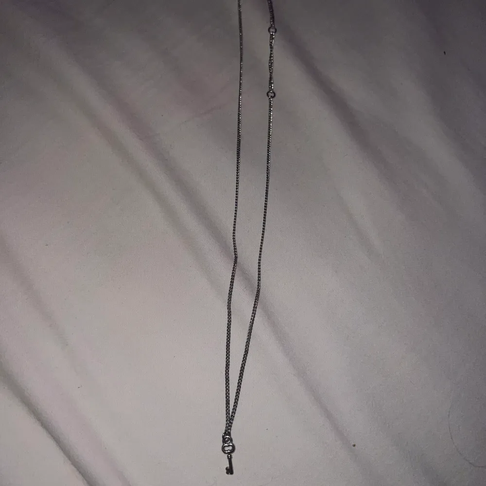 Ett fint halsband med en liten nyckel som detalj. Inte speciellt långt och är ett väldigt gulligt halsband.. Accessoarer.