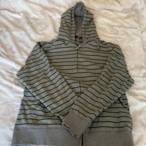 En randning tjocktröja med dragkedja  - Detta är en thrifted grå tjocktröja med gröna ränder på. Den är i storlek XL och är använd några få gånger.