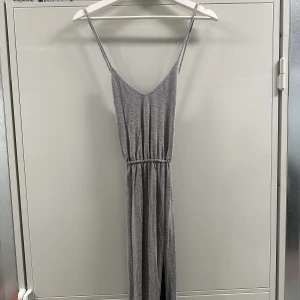 Långklänning  - Långklänning med korsad rygg och slits på ena sidan från Ivyrevel. 