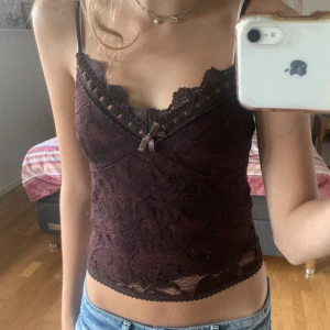 Spetstopp - Mörkbrunt spetslinne från Urban outfitters. Spetsdetalj längs alla kanter och en rosett längst fram🤎