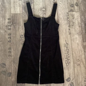 Svart klänning med dragkedja  - Svart klänning med dragkedja som går hela vägen ner. 