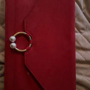 Röd kuvertväska för 100kr En vit fläck som ni kan se på bilden 