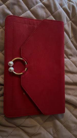 Röd kuvertväska för 100kr En vit fläck som ni kan se på bilden 