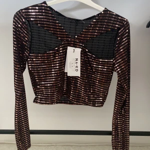 Topp - Hej, säljer nu en fest topp i storlek M ifrån NA-KD som aldrig är använd , sjukt snygg när man ska på någon fest. Mycket detaljer, hålen sitter över brösten.