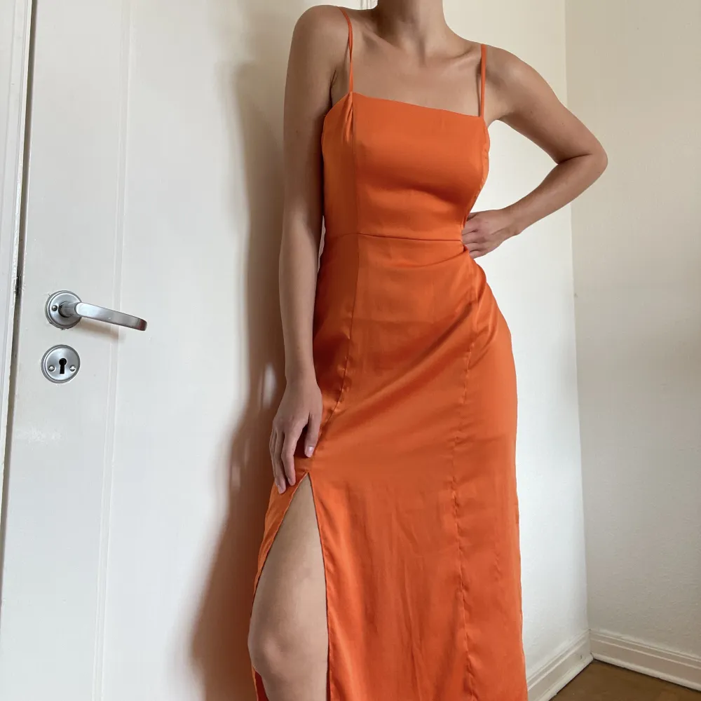 Superfin, simpel orange slipdress från Monki i storlek 38 med en slit längs benet. . Klänningar.