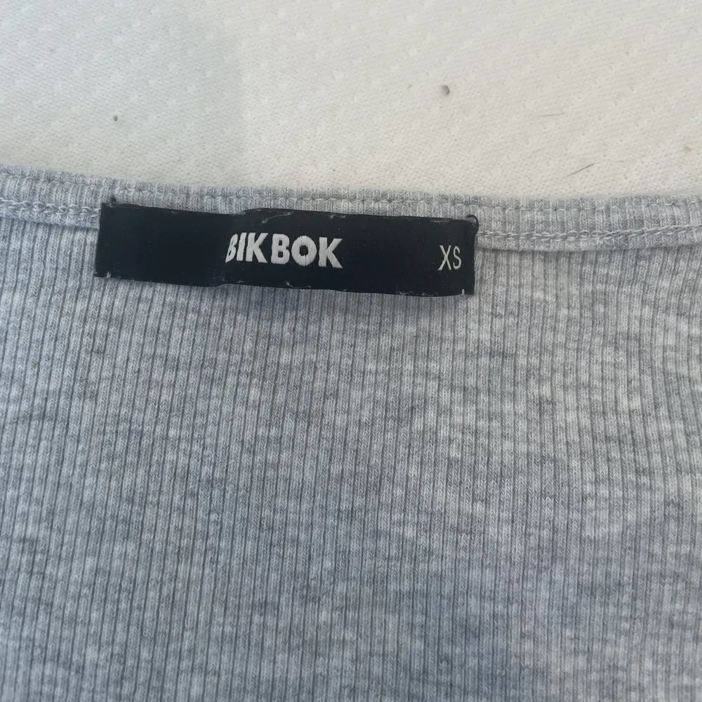 En grå T-shirt med dragkedja fram, från Bikbok i storlek XS.  Minns inte sist det användes men den är bara använd några få gånger för möjligtvis 1-2 år sedan annars har den bara legat i lådan.  Kan tvättas innan den skickas/hämtas . T-shirts.