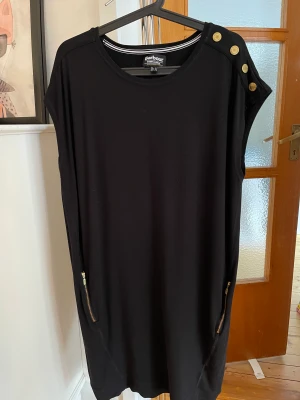 Fin Barbour-klänning - Fin Barbour-klänning i storlek 44. Väldigt bevarad i färg och kvalitet, endast några märken/slitage på knapparna efter tvätt.  Jätteskön och passar alla mellan S-L beroende på hur man vill att den ska sitta. 