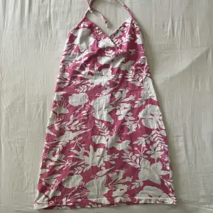 Supersöt rosa-vit blommig halterneck klänning med stretch i ryggen. Begagnat skick, men inga fläckar eller hål! Passar XS-S🫶💕