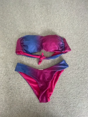 Bikini  - Rosa, lila/blå glittrig bikini från Italien. Färgen byts beroende antingen på temperatur eller om den är blöt eller inte, har aldrig använt bikinin så vet ej.