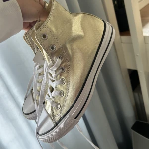 Converse skor - Säljer mina helt nya guldiga converse  med prislappen på som är så unika! Köpte de för 800kr men säljer de nu för 300kr. Det är storlek 39 men de är väldigt stora i storleken så skulle säga att de är som storlek 40
