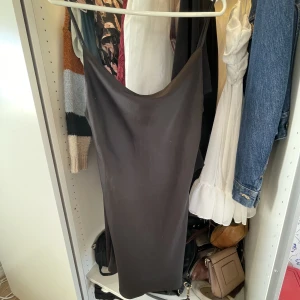 Svart satinklänning - Superfin classy svart satinklänning från Urban Outfitters. Sitter löst runt bysten och har lite lägre rygg. Den går att spänna över axlarna. Använd 2-3 gånger. Storlek M men den är liten i storleken, jag skulle säga snarare S!