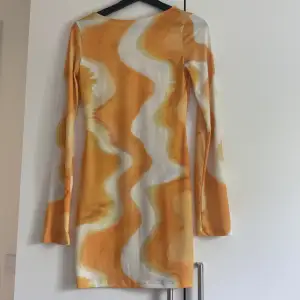 En jätte fin mönstrad gul/orange klänning med öppen rygg som är köpt på NA-KD.   Köparen står för frakten🌸