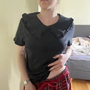 T-shirt med detalj i kragen - Jättefin svart tröja med en underbar krage. Köpt för ett halvår sedan. Pga viktuppgång så blir den för tight på mig nu, men har älskat denna tröja. Lapp är bortklippt men gissar att tröjan är en L