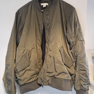 Grön Bomberjacka stl 38 - Superfin bomberjacka. Inte mycket använd. Inga skavanker som jag kan hitta. Skön att ha på sig.