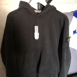 Stone island hoodie - Säljer denna riktigt snygga stone island hoodien som är i helt ok skick, 7/10. Säljer då jag är i behov av pengar och är villig att gå ner i pris vid snabb affär. Vid minsta fråga kontakta gärna😁