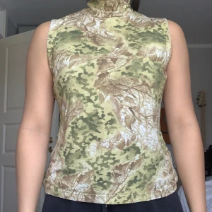 Grön Ärmlös Polo - En grön ärmlös polo med fint mönster. I storlek XL och är väldigt stretchig.