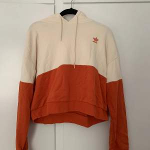 En tunn och kort hoodie med luva från Adidas 