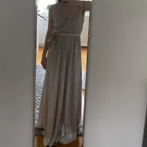 Balklänning  - En balklänning som aldrig kommit till användning, lapp kvar! Klänningen är i en rosa silver färg💗 
