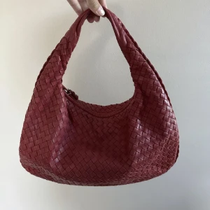 Bottega veneta väska - Tänkte nu sälja min underbara röda medium veneta väska från bottega veneta, köpt på the vintage bar april 2021 och använd väldigt sparsamt av mig så är i väldigt bra skick! Finns box, kvitto och äktighetsbevis. Fler bilder kan skickas vid intresse!