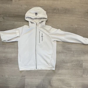 Sail racing hoodie - En vit Sail racing hoodie i storlek 160. Inga märken eller defekter utom att dragkedjelöparen vid bröstfickan ramlat av.
