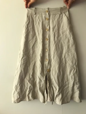 Kjol från &Other Stories  - Beige kjol med knappar från Other Stories, gott skick i storlek 34. 