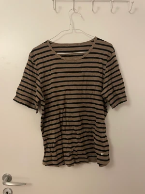 Randig t-shirt - T-shirt från cappucini, brun/svart-randig. Storlek M/L
