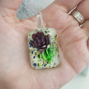 Hängsmycke - Ett hängsmycke i glas. Kommer inte ihåg exakt vem den är köpt av men den är antagligen köpt på en marknad och handtillverkad!🌸