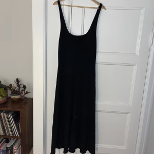 Klänning - Denna klänning har ett väldigt speciellt nästan glansigt tyg. Den är liksom nästan stickad så strukturen e fin och nästintill genomskinlig