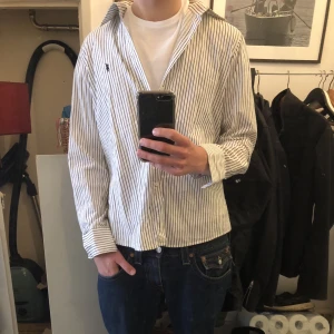 Ralph Lauren skjorta  - Ralph Lauren skjorta med vita och svarta ränder. Bra skick utan några defekter. Nypris: 1600. Skriv gärna om du har några frågor!