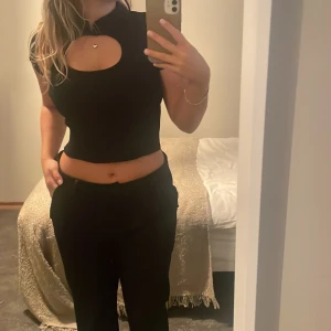 T-shirt - T-shirt från Gina i lite tjockare tyg. Knäpps vid halsen med en knapp. Storlek M men liten i storleken 