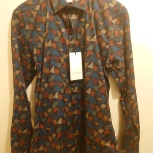 Ny Lindbergh white skjorta  - Helt ny skjorta från Lindbergh white i snyggt färgat mönster black och stretch kvalitet i storlek S Org tags och pris lapp på 600 kr kvar  Mitt pris 199 kr plus frakt 