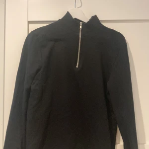 Svart half zip - Svart halfpipen bra skick, 2 små hål vid höger bröst/axel men man tänker knappt på de