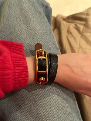Balenciaga armband  - Supersnyggt Balenciaga armband. Köpt 2017 men sparsamt använt så ser som nytt ut när det sitter på. Lädret har blivit lite torrare med åren, eventuellt lite torra sprickor, eller smink som lagt sig i, kan inte avgöra riktigt (se bild 3). 1500 ex frakt ☺️