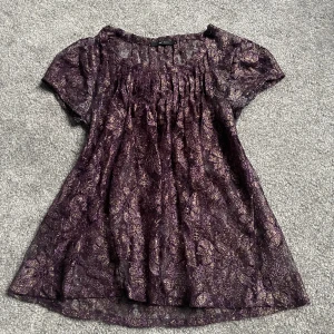 Vintage topp  - Lila glittrig t-shirt (blus) som är i ganska tunt genomskinligt material. 