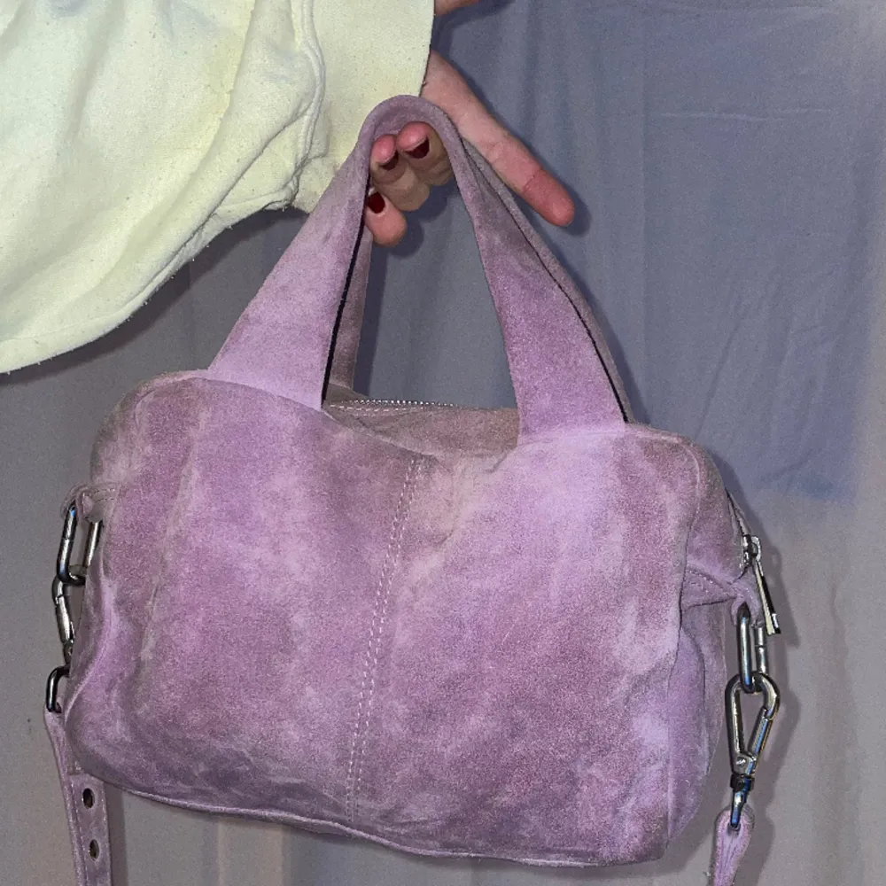 Väska i mocka från nunoo! Använd så har några fläckar men går säkert att få bort med mockaborste. Finns ett längre avtagbart axelband (syns på 3e bilden). Väskor.