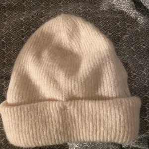 Stickad vit mössa - Säljer denna stickade mössa från H&m, ej använd, endast testad. Materialet är superskönt och varmt, perfekt nu till vintern!