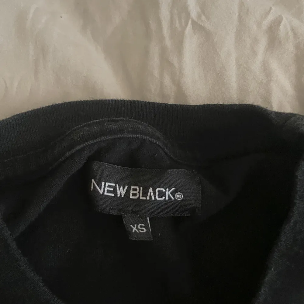 En svart lite tjockare långärmad med rosa tryck på från new black . T-shirts.