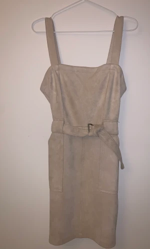 Klänning Mocka-imitation - Fin klänning från Bershka, använd 2 gånger, så skicket är som nytt. Dragkedja i ryggen, fickor framtill och ett band i midjan