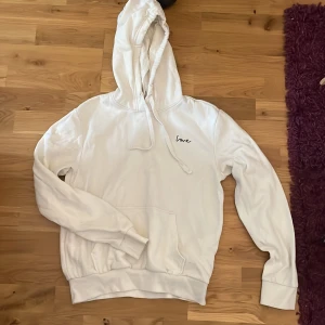 Vit hoodie - Storlek XS från H&M. Vit hoodie  med trycket LOVE och med luva.  Lite knottrigt på tyget. Använd ett par gånger. Fin på🤍 säljer för att den inte passar längre. 