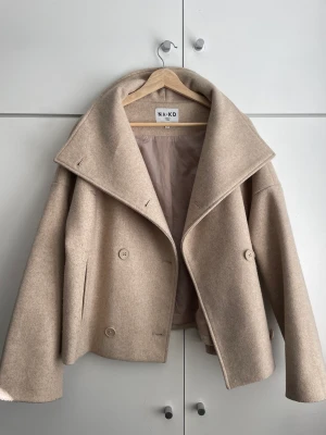 kort kappa - superfin beige kappa från na-kd 😀slutsåld på hemsidan men nu säljer jag min pga fel storlek 😔skriv privat om du har fler frågor