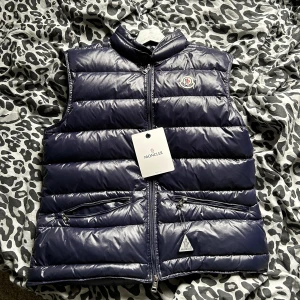 Mörkblå Moncler väst - Moncler väst gui night blue. En dunväst från Moncler i stilrent skick. Jag köpte västen för 1 månad sen och den är lite för liten för mig. Så jag har använt den cirka 3 gånger.