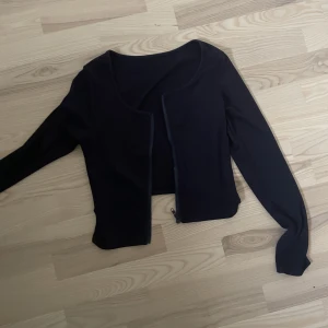 Långärmad topp - Marinblå långärmad topp köpt secondhand. Går att dra ned dragkedjan så funkar även som kofta. Säljer då den inte är min stil