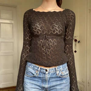 Långärmad virkad - Tröja med låånga ärmar. Knytes där fram med ett snöre