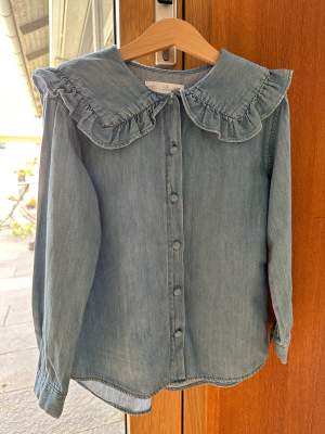 Nyskick, använd endast en gång. Söt och mjuk jeansskjorta/blus från Zara med krage med volang. 